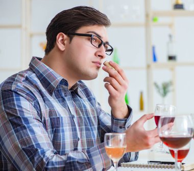 Profesyonel şarap garsonu kırmızı şarap tadıyor.