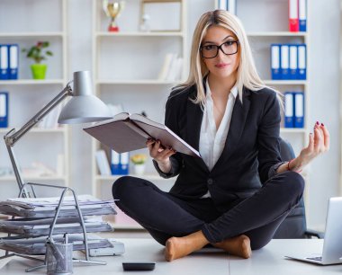 İş kadını ofiste meditasyon yaparken hayal kırıklığına uğradı