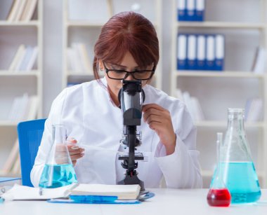 Bir laboratuarda deney yapan kadın bir bilim adamı.