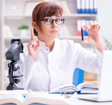 Bir laboratuarda deney yapan kadın bir bilim adamı.