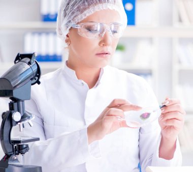 Bir laboratuarda deney yapan kadın bir bilim adamı.