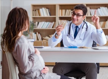 Hamile kadın muayene için doktoru ziyaret ediyor.