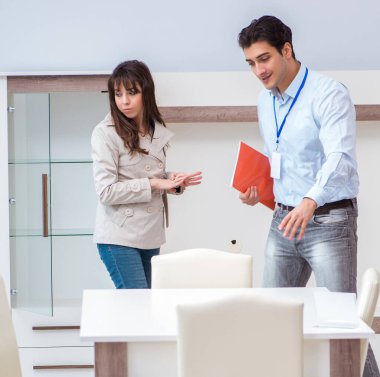 Satıcı mobilya dükkanındaki kadın müşteriye açıklama yapıyor.