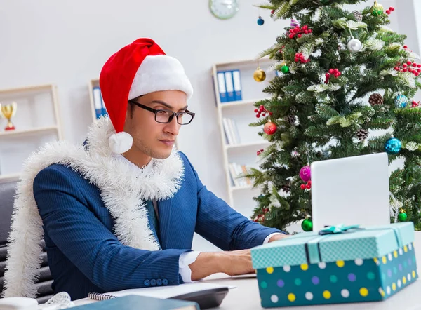 İş adamı Noel tatilini ofiste kutluyor.