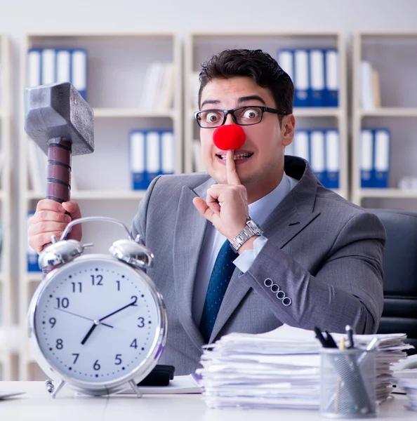 Homme d'affaires clown dans le bureau avec marteau et réveil — Photo