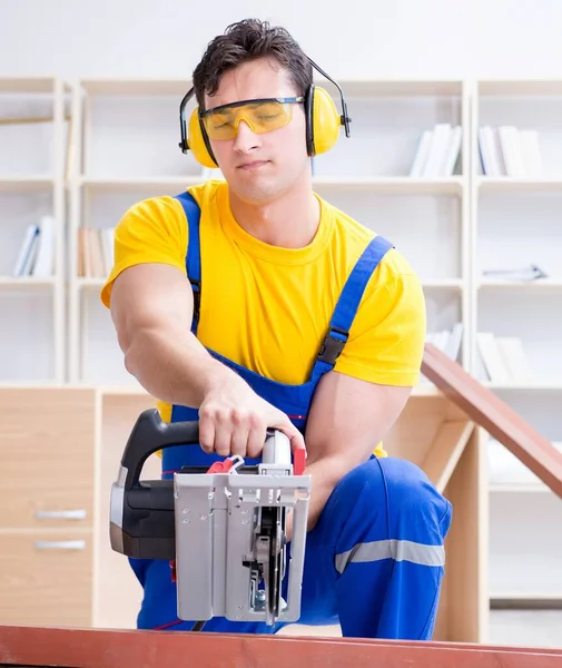 Repairman carpenter cutting sawing a wooden plank with a circula — Stock Photo, Image