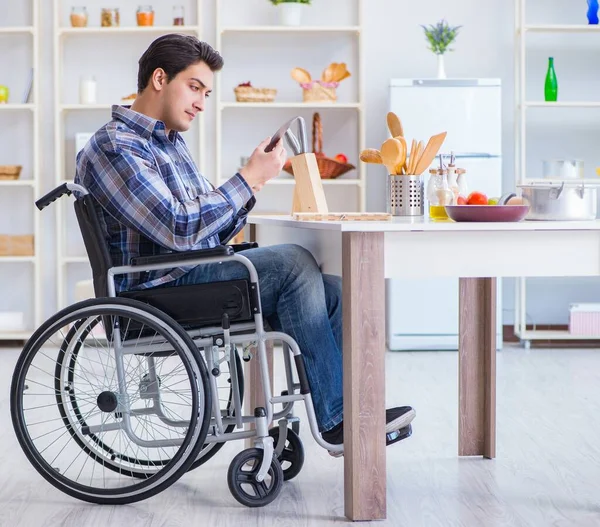 Engelli genç koca mutfakta çalışıyor.