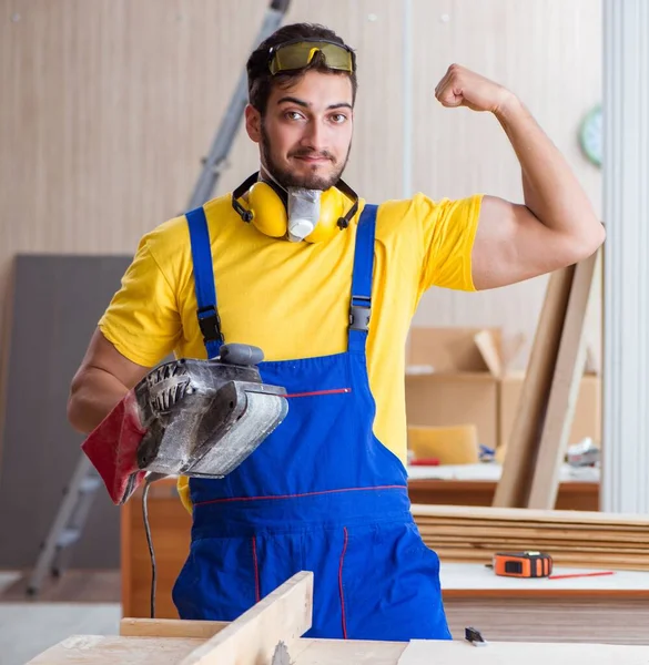 Giovane carpentiere riparatore che lavora con elettroutensili poli elettrici — Foto Stock