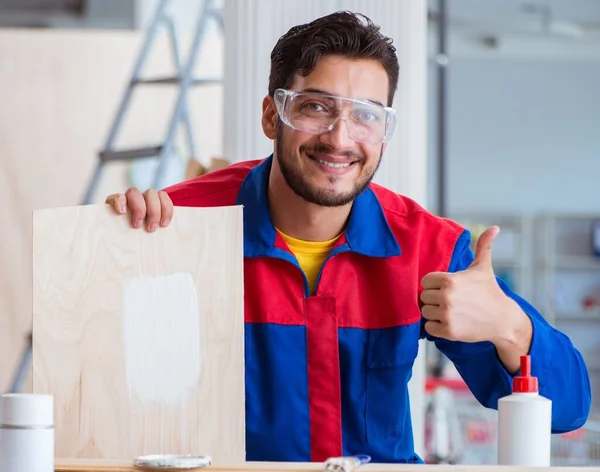 Yooung marangoz boyayla uğraşıyor.