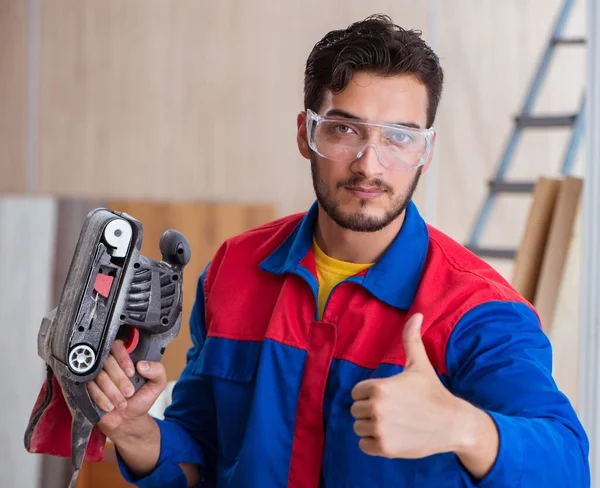 Mladý opravář pracující s motorovou pilou — Stock fotografie