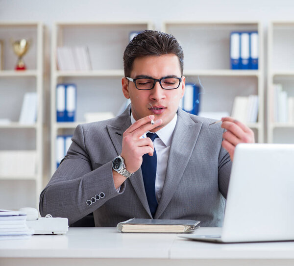 Businessman smoking in office at work