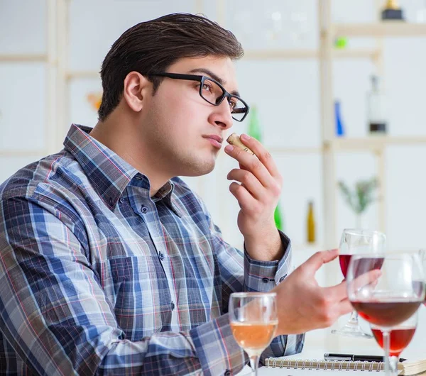 Profesyonel şarap garsonu kırmızı şarap tadıyor.
