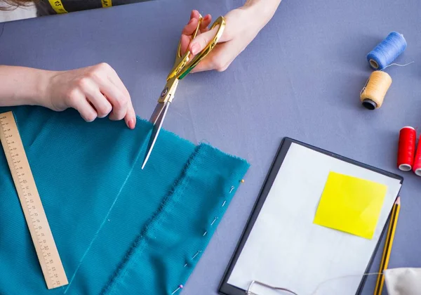 Kadın terzi dikiş dikmek için dikiş dikiyor.