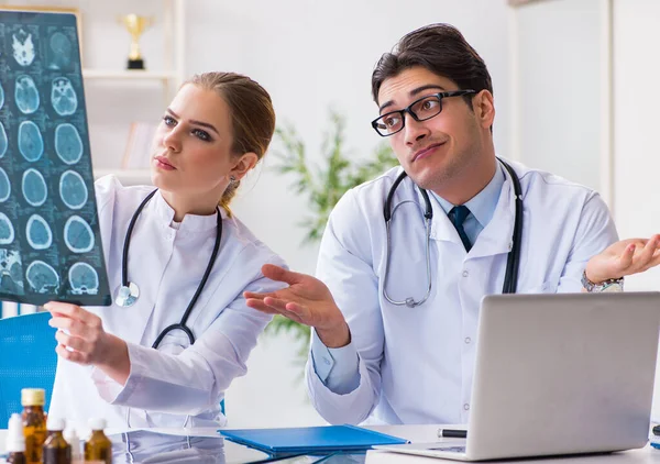 İki doktor teşhis için hastanın röntgen görüntülerini inceliyor.