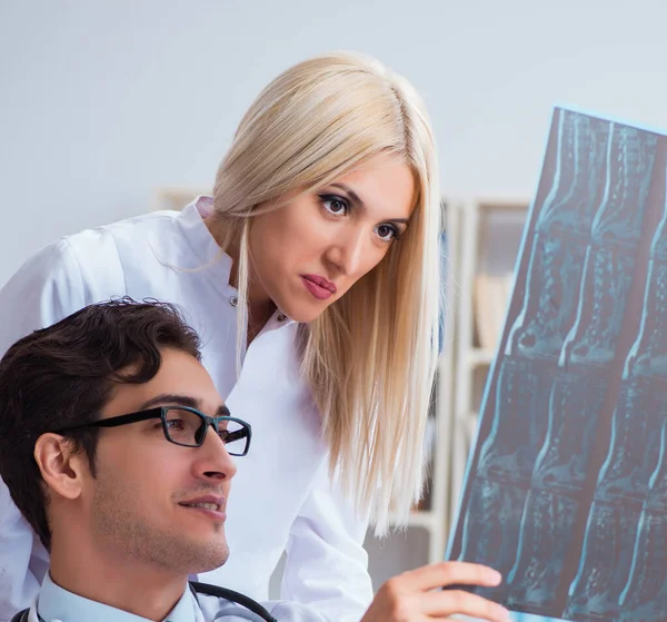 Zwei Ärzte untersuchen Röntgenbilder des Patienten zur Diagnose — Stockfoto