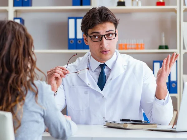 Doktor gözlükçü bir hastaya reçete yazıyor.