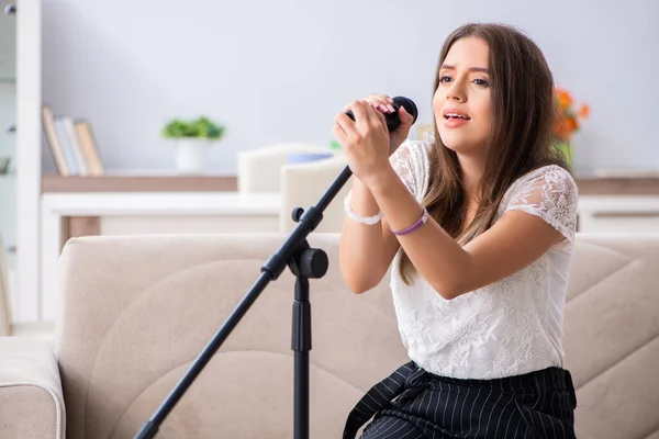 Vrouwelijke mooie muzikant die thuis zingt — Stockfoto