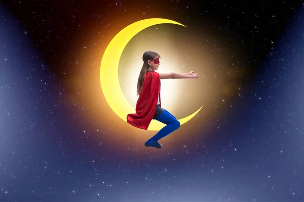 Superhéroe niño sentado en la luna creciente — Foto de Stock