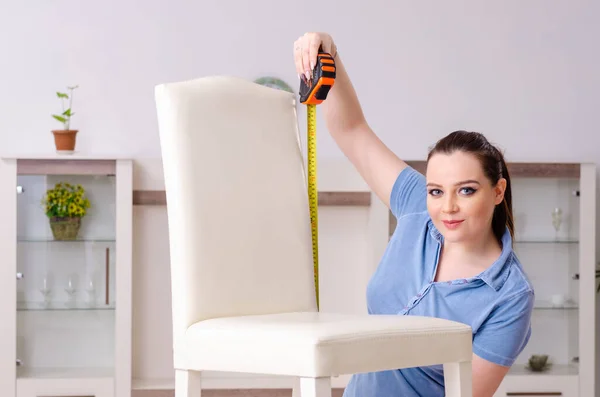 Giovane donna che ripara sedia a casa — Foto Stock