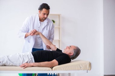 Yaşlı adam genç doktoru ziyaret ediyor.