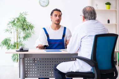 Genç erkek müteahhit yaşlı doktoru ziyaret ediyor.