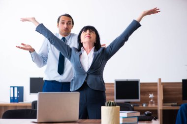 Ofiste spor egzersizleri yapan iki çalışan.