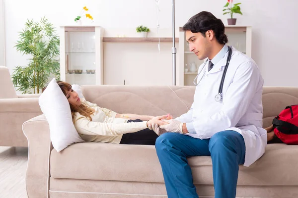 Genç, yakışıklı doktor, kadın hastayı evinde ziyaret ediyor.