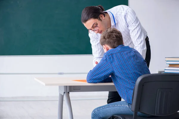 Jonge mannelijke leraar en jongen in de klas — Stockfoto