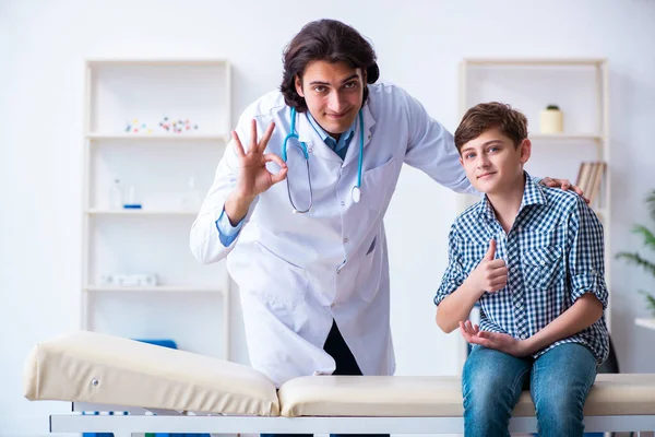 Fiatal orvos vizsgálja iskolás fiú rendszeres ellenőrzés — Stock Fotó