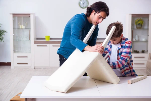 Jovem carpinteiro ensinando seu filho — Fotografia de Stock