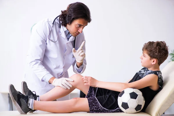 Giocatore di calcio ragazzo visita giovane medico traumatologo — Foto Stock