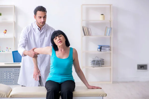 Joven médico masculino examinando paciente anciano femenino — Foto de Stock