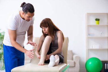 Genç doktor travmatoloğu ziyaret eden bacağı yaralı bir kadın.