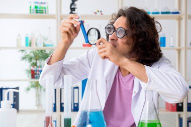 Laboratuvarda çalışan komik erkek kimyager.