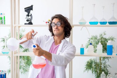 Laboratuvarda çalışan komik erkek kimyager.