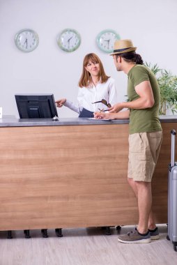 Otel resepsiyonundaki genç adam.