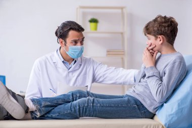 Genç çocuk hastanede doktoru ziyaret ediyor.