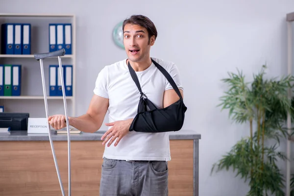 Junger Mann an der Rezeption eines Krankenhauses — Stockfoto