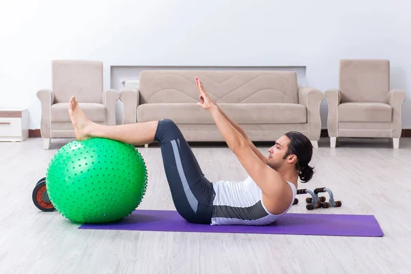 Jovem treinando e exercitando em casa — Fotografia de Stock