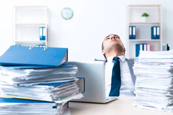 Empresário com carga de trabalho de papelada pesada — Fotografia de Stock