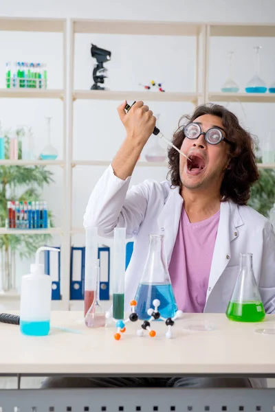 Grappige mannelijke chemicus die in het lab werkt — Stockfoto