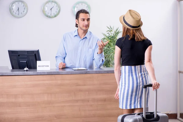 Jonge vrouw bij hotelreceptie — Stockfoto