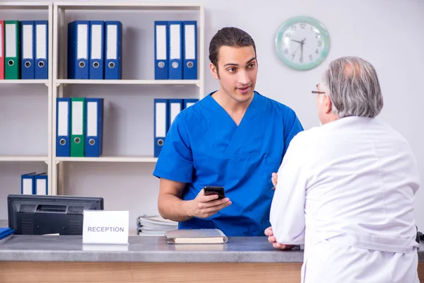 Hastanedeki resepsiyonda iki doktor konuşuyor. — Stok fotoğraf