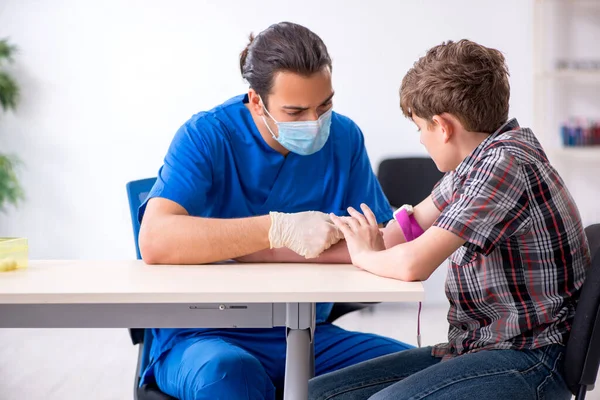 Genç çocuk hastanede doktoru ziyaret ediyor.