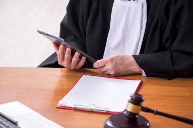 Adliyede çalışan yaşlı bir erkek yargıç.