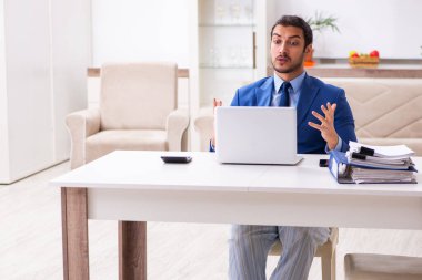 Evden kendini izole etme konseptiyle çalışan genç bir erkek işçi.