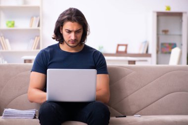 Evden çalışan genç bir adam.