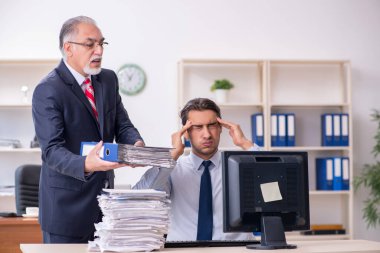 Eski patron ve genç erkek çalışan ofiste.