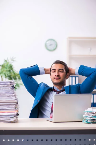 Joven empleado masculino infeliz con el trabajo excesivo —  Fotos de Stock