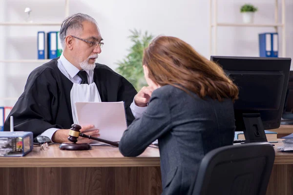Starý muž soudce a žena klient v kanceláři — Stock fotografie